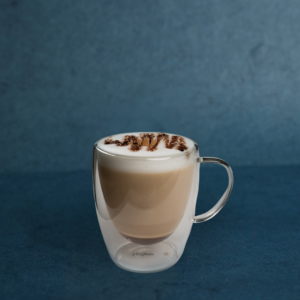 Flavored latte served in a clear glass mug with foamed milk, available in caramel, vanilla, hazelnut, and sugar-free options.