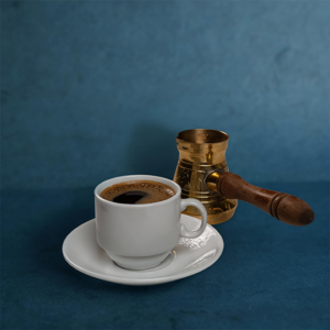 Classic Turkish coffee, served in a cup and saucer with a traditional brass pot.