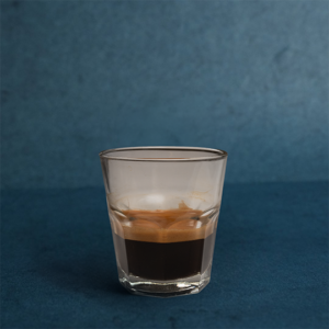 Classic doppio espresso, served in a clear glass.