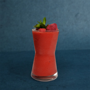 Refreshing strawberry juice served in a tall glass, finished with fresh strawberries and mint