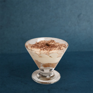 Classic tiramisu presented in a glass, featuring creamy layers and a dusting of cocoa powder.