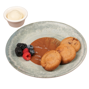 Three warm mini cookies with molten chocolate centers, served with fresh mixed berries on a ceramic plate.